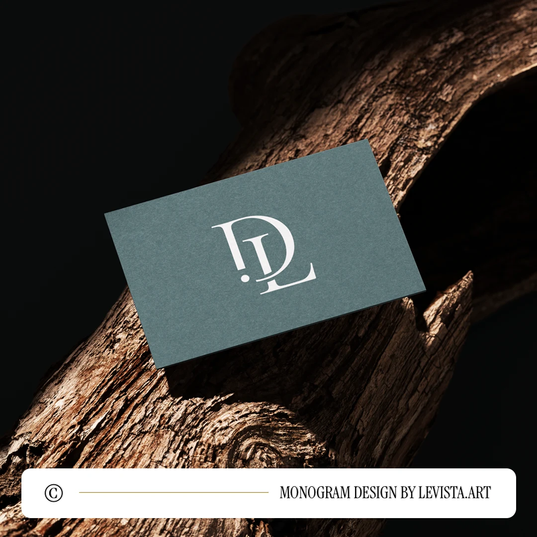White DL letter logo as minimalist interlocking initials design on a light green business card lying on a decorative brown wood for branding, embossing and high-quality stationery print