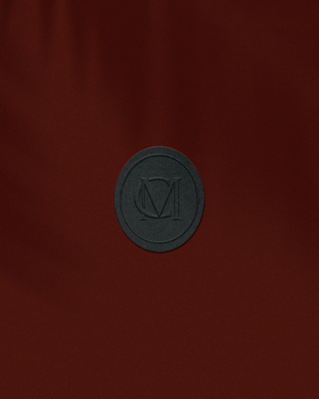 MC monogram on tag wine store branding Vertical close-up of a CM monogram logo tag for luxury wine store branding