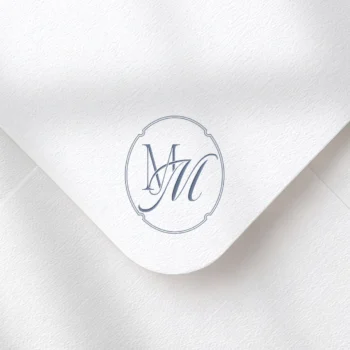 Light blue MM letter logo as refined initials design on a textured envelope for stylish wedding invites & luxury mailing