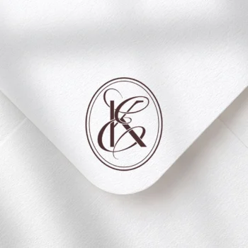 Burgundy KE and EK wedding monogram with semi-bold interlocking letters as premium initials design on a textured envelope for luxury stationery, invites, mailing and décor