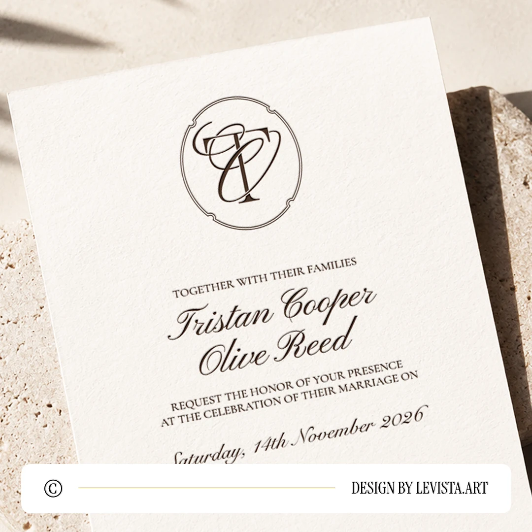 Coffee brown TO and OT wedding monogram with thin interlocking letters as premium modern initials logo design with couple names on an invitation card lying on a light brown sandstone for exquisite stationery, invites, mailing and décor